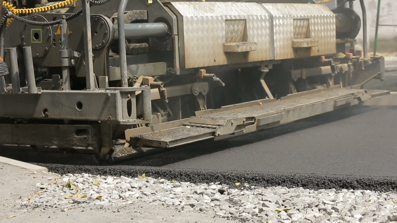 Construction And Repair On The Road. Tracked paver at asphalt pavement works for road under construction