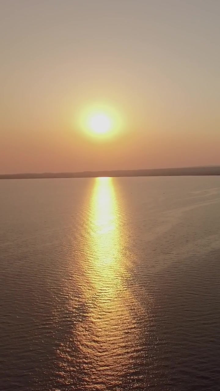 Sea and coastal town at sunset, aerial. Distant view of Trikorfo Beach, Greece