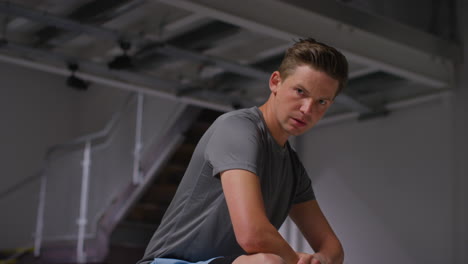 Portrait-Of-Determined-Male-Athlete-Sport-Training-In-Gym-Sitting-And-Concentrating-In-Changing-Room-With-Focused-Expression-10