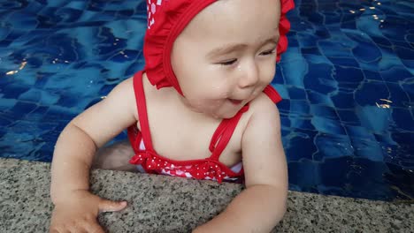 niña caucásica en lindo traje de baño disfrutando del agua en una piscina cubierta