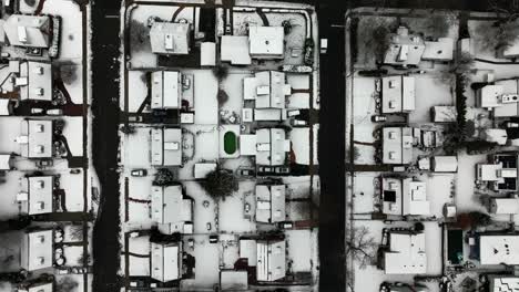 una vista aérea, de arriba hacia abajo sobre un tranquilo barrio suburbano después de una tormenta de nieve en este día nublado