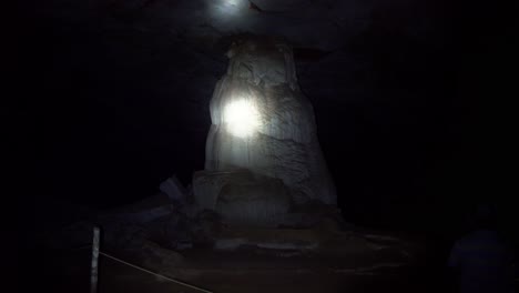 handheld shot of a flashlight lighting up a huge cave column inside the famous lapa doce cave in the chapada diamantina national park in bahia, northeastern brazil