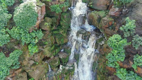 Aerial-drone-footage-of-a-tall-rocky-waterfall-in-the-Yorkshire-Dales,-Pennies