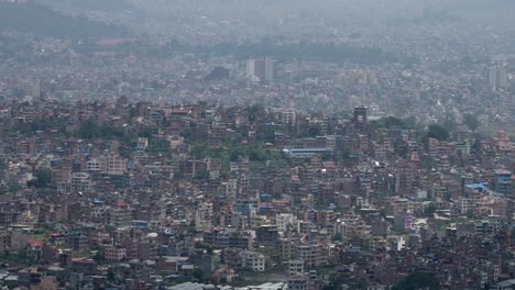 A-panning-aerial-view-of-the-city-of-Kathmandu,-Nepal-on-a-cloudy-day-at-the-beginning-of-rainy-season