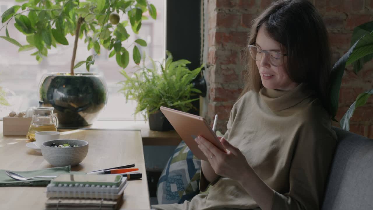 mujer trabajando en una tableta en un café