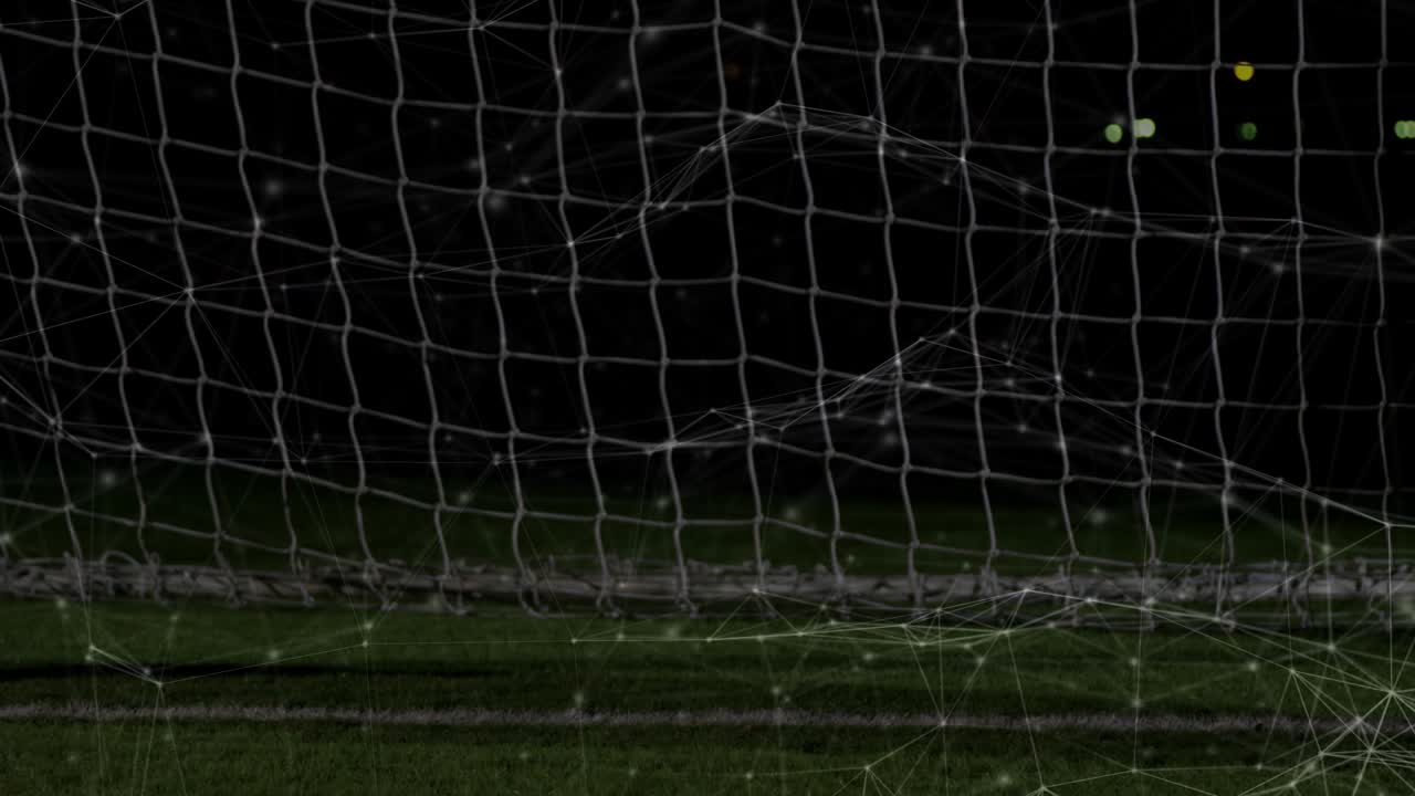 Şut sonrası topa atlayan, eldivenli elleriyle topu kurtarmak için kaleye doğru uzanan futbol kalecisi