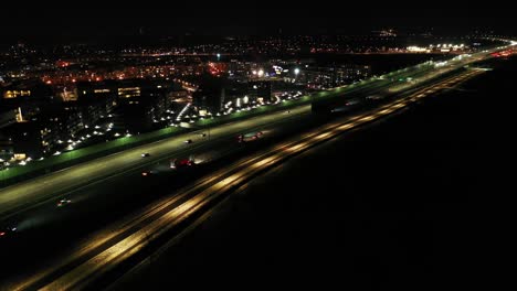 drone shot of night traffic on a motorway showing cars and lanes of light with tunnel and viaducts outside the city of warsaw, poland. moving the camera forward.