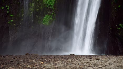 powerful waterfall cascading down lush green cliffs in munduk, bali, indonesia