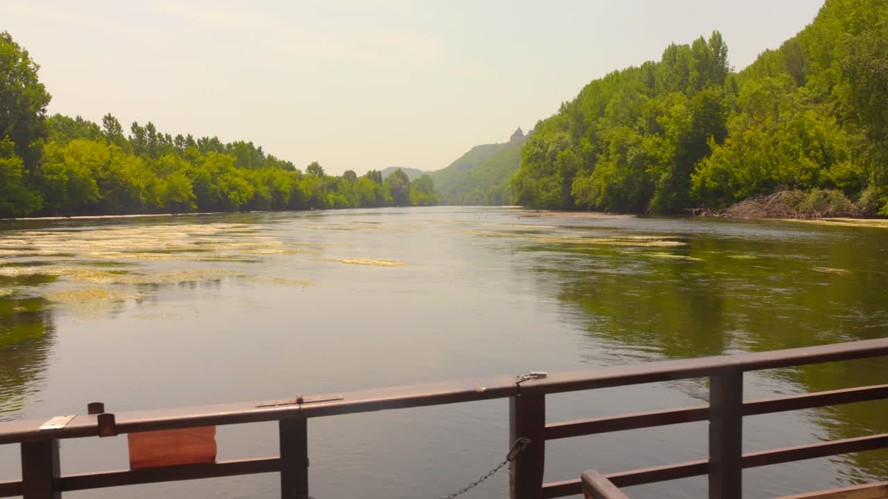 A peaceful view from the deck of a traditional gabare boat, as it cruises serenely down the beautiful and historic Dordogne River in France