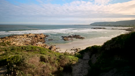 sunset view from hermanus coastal dune with vegetation over beach and coastline