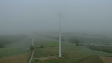 靠近風力發電廠的空中影像, 霧<unk>時的風車, 灰色風景周圍, 開放式的可再生能源, 自然風景下方, 綠色能源是重要的