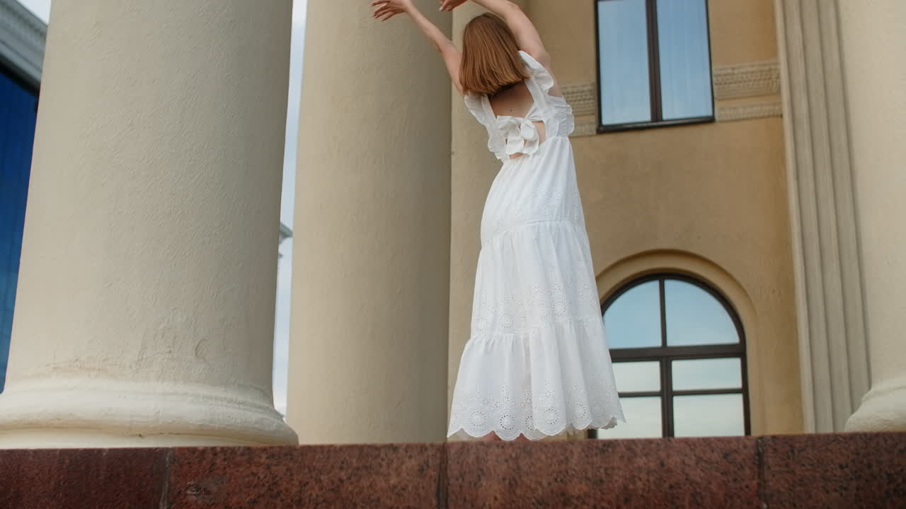 Woman dancing in a white dress outdoors