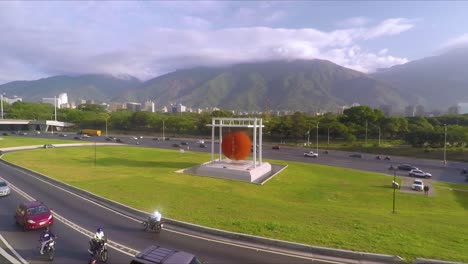 drone video of 'esfera caracas' with the street in the foreground and the highway and the ávila mountain at the background