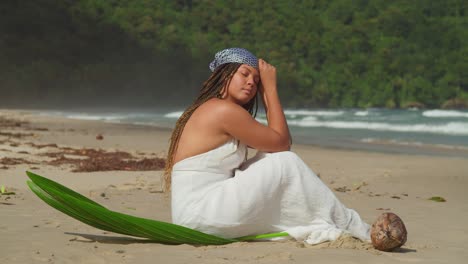 Cerrar-Cámara-Lenta-De-Una-Mujer-Joven-En-Un-Vestido-De-Playa-Sentado-En-La-Playa-En-Una-Isla-Tropical