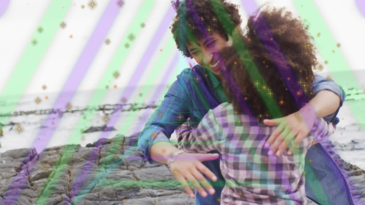 Father and child hugging on rocky beach with colorful animation overlay