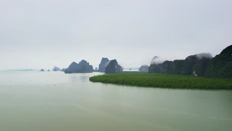 vistas panorámicas a través de las aguas de la bahía de phang nga en tailandia con manglares a lo largo de la costa