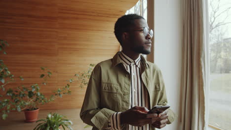 African-American-Man-Typing-on-Phone-in-Library-Auditorium