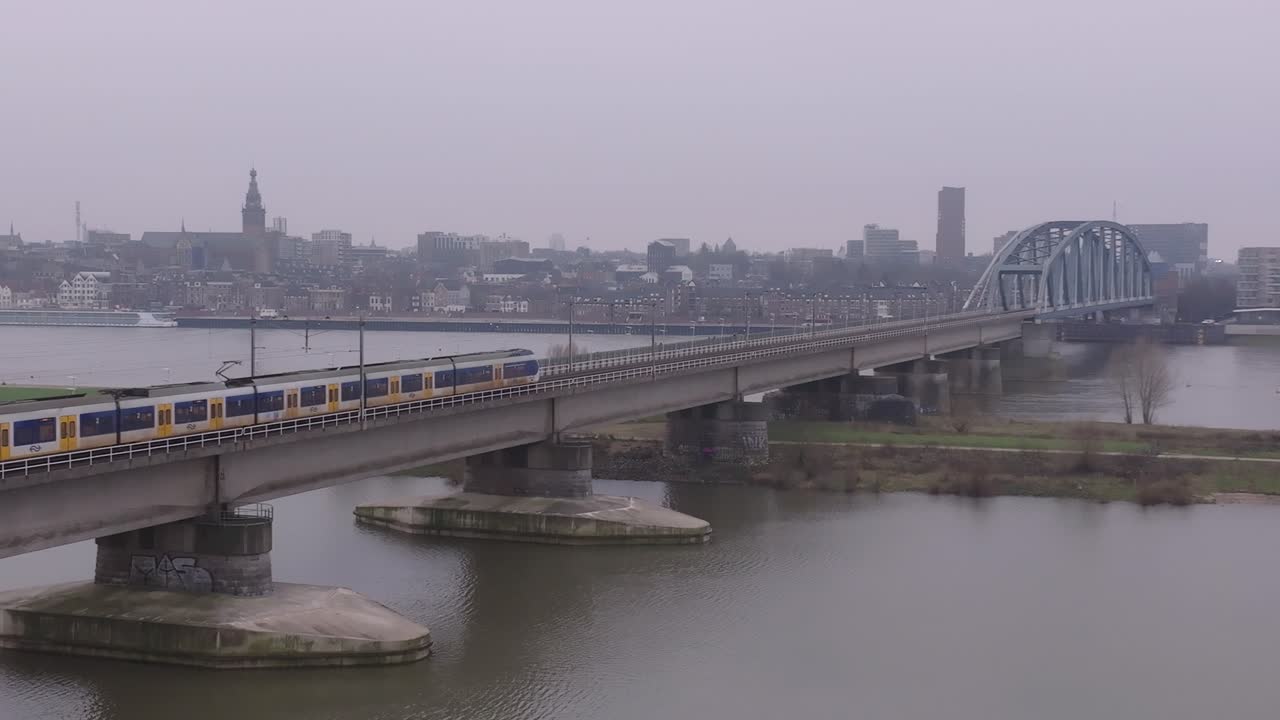 Ripresa aerea di treni che attraversano il ponte ferroviario di Nimega