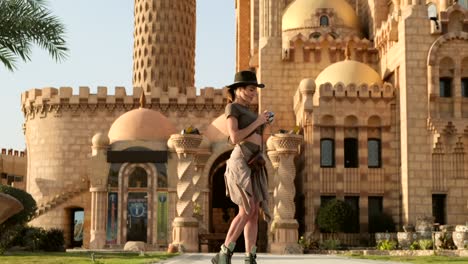 beautiful woman looks at the camera and takes a photo on the background mosque