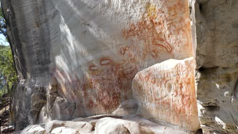 First-nations-peoples-rock-art-showing-paintings-of-boomerangs,-hands,-feet,-stone-axes,-shields,-nets-and-an-assortment-of-animal-tracks