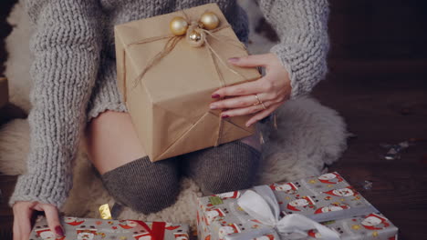 gift box new year day celebration. young attractive woman with gift box near fireplace