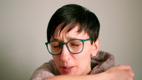 close up view of a mid ages lady sneezing and coughing to elbow