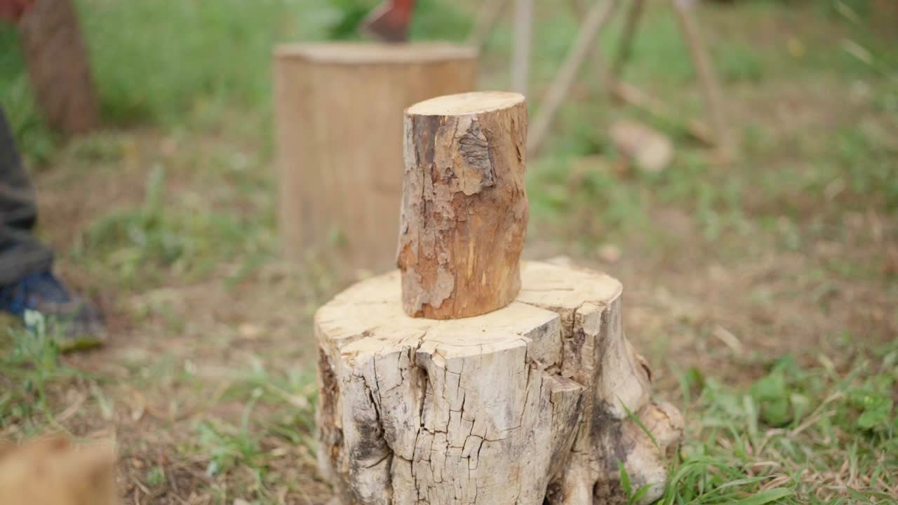 Person chopping wood with an axe outdoors