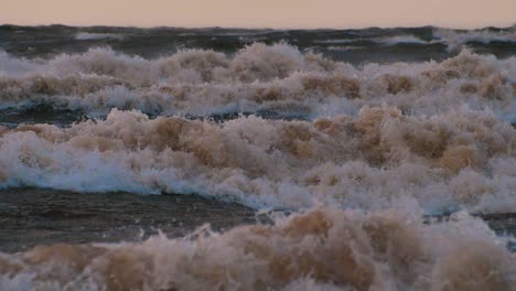 sea storm with big waves at sunset