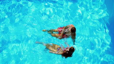Happy-couple-swimming-in-clear-blue-pool-