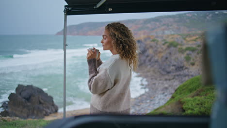 romantic lady resting seashore holding coffee cup. relaxed woman drinking tea