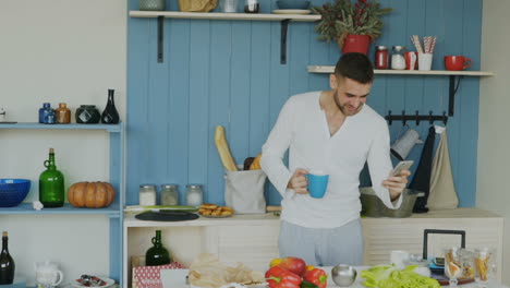 man using phone in kitchen during breakfast