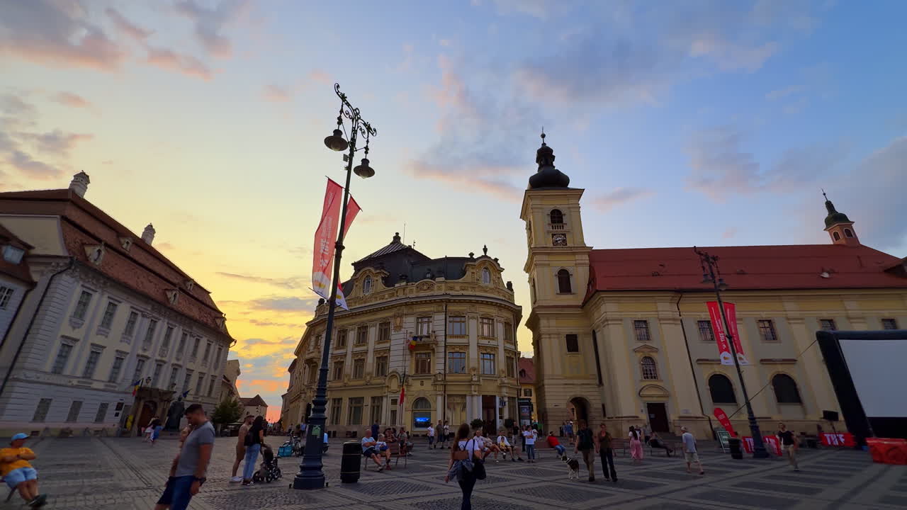 Sibiu, Romania, 1 July 2025: Council Square in Sibiu during sunset. Panoramic view of the central square in Sibiu Romania with people and historic architecture at sunset