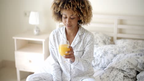 una chica afroamericana bebiendo jugo.