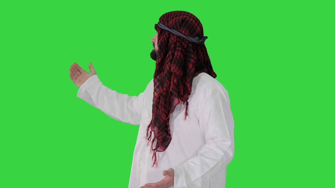 케피예를 입은 셰이크가 녹색 스크린, 크로마 키에서 환영 제스처를 하고 있습니다.
