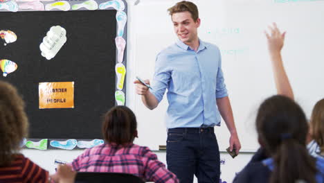 teacher using whiteboard in an elementary school lesson