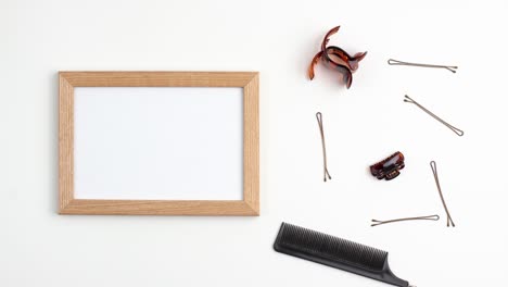 stop motion animation mockup wooden frame flat lay of comb for separating hair hairpins of the right side of the image template with copy space on white background. hairdresser salon equipment concept