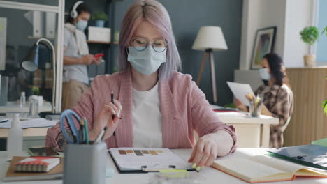 woman working at office desk during covid-19 pandemic