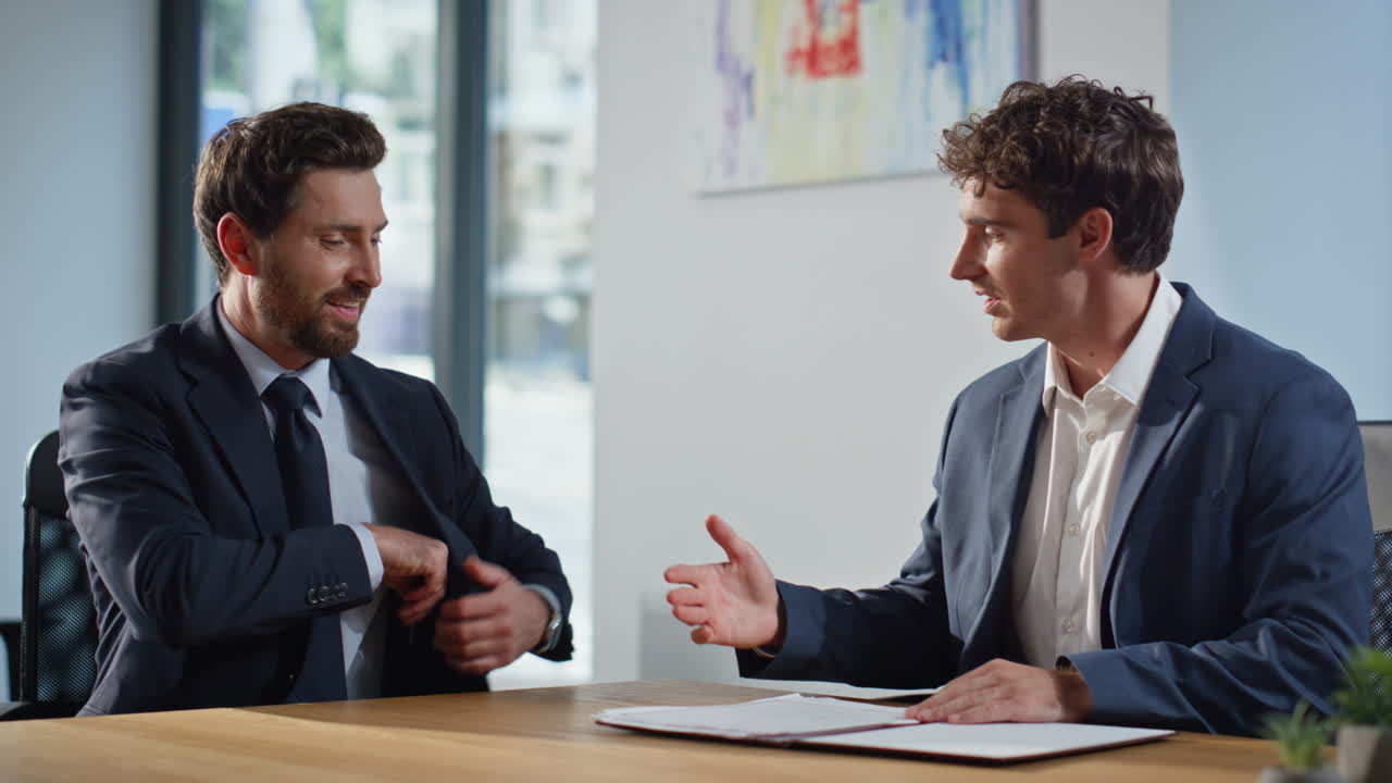 Two businessmen concluding partnership in office closeup. Partners shaking hands
