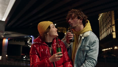 Romantic-couple-enjoying-time-together-under-bridge.-Pair-blowing-into-bottles.