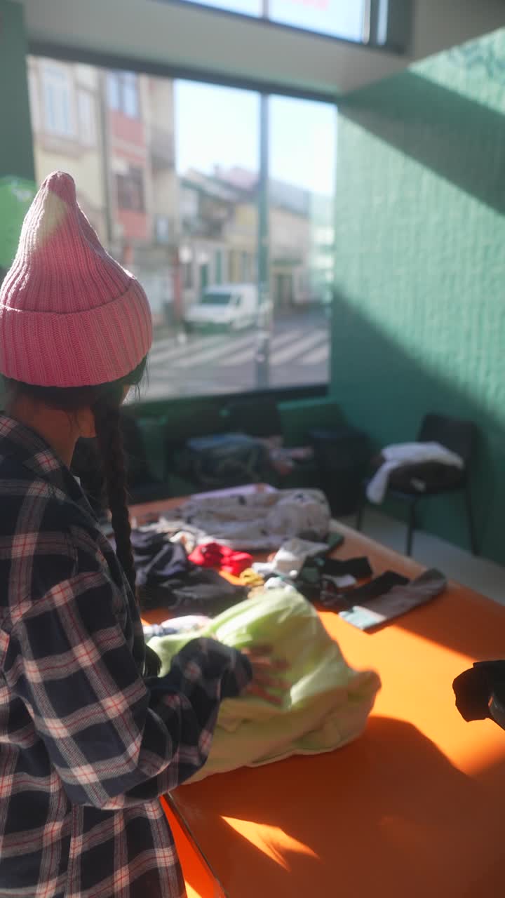 mujer clasificando ropa en un centro de donación