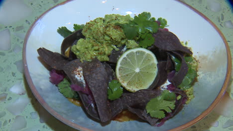 blue corn tortilla dish with guacamole and lime
