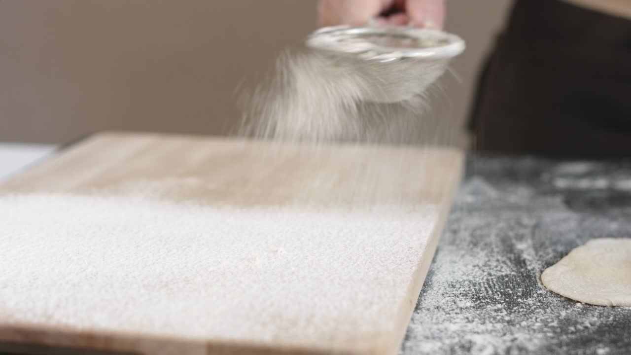 Two hands making dough for meat dumplings.