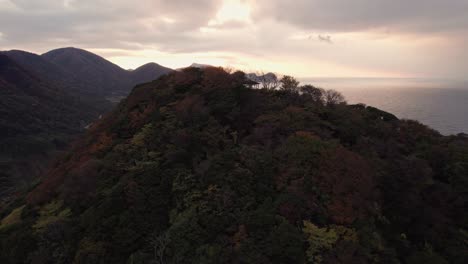 Paisaje-Aéreo-De-Puesta-De-Sol-En-La-Cima-De-La-Montaña-De-Kyotango-Kyoto-Destino-De-Viaje-De-Playa-Surrealista-De-Japón,-Colinas-Boscosas-Divinas,-Estableciendo-Un-Disparo-En-La-Costa-Del-Mar