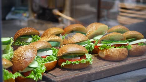 assortment of small sandwiches on a wooden board
