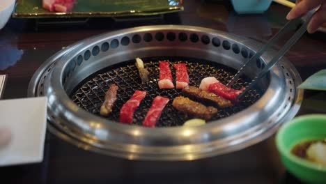 4k delicious wagyu beef being placed on yakiniku grill in japanese restaurant