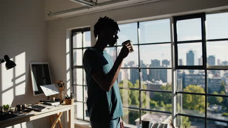 man drinking coffee by the window