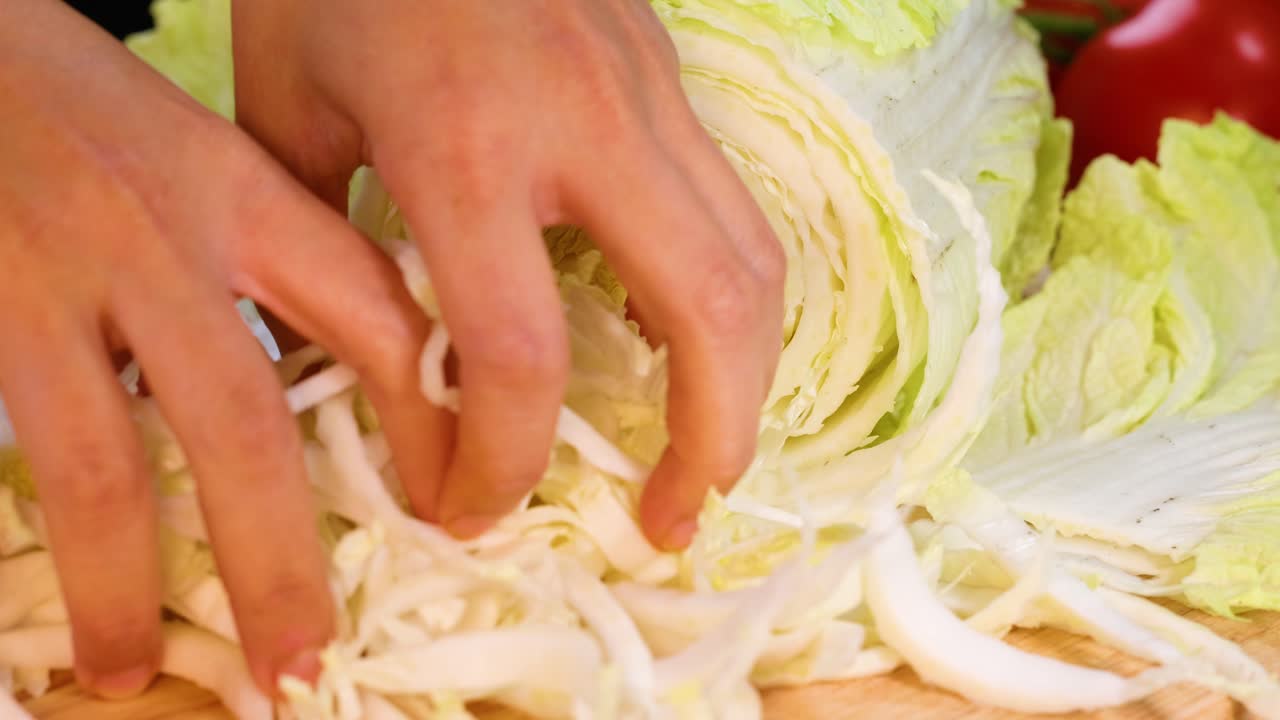 손은 절단판에 중국 고추를 고 있습니다.