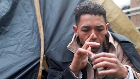 homeless man sitting in a tent