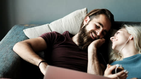 Couple-kissing-while-listening-music-on-mobile-phone-in-living-room-4k