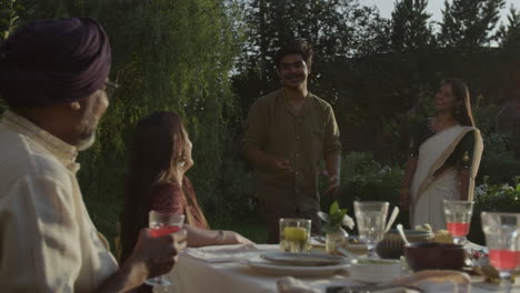 joyful indian family and friends gathering for an outdoor dinner party
